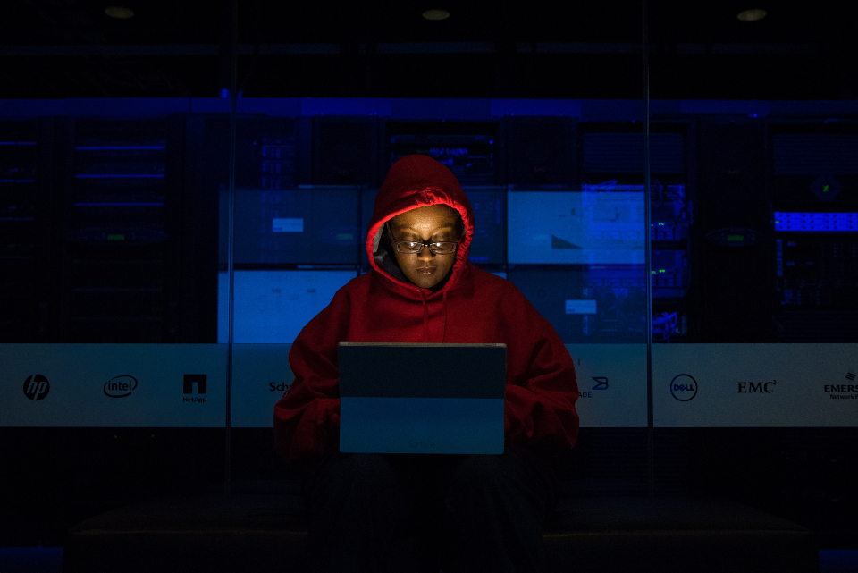 A security analyst working at a keyboard in a dimly lit room