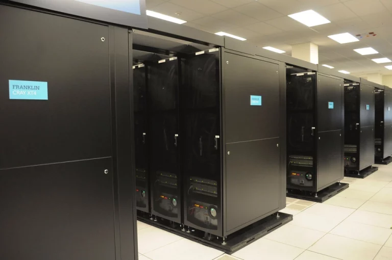 Rows of supercomputer server racks in a data centre aisle